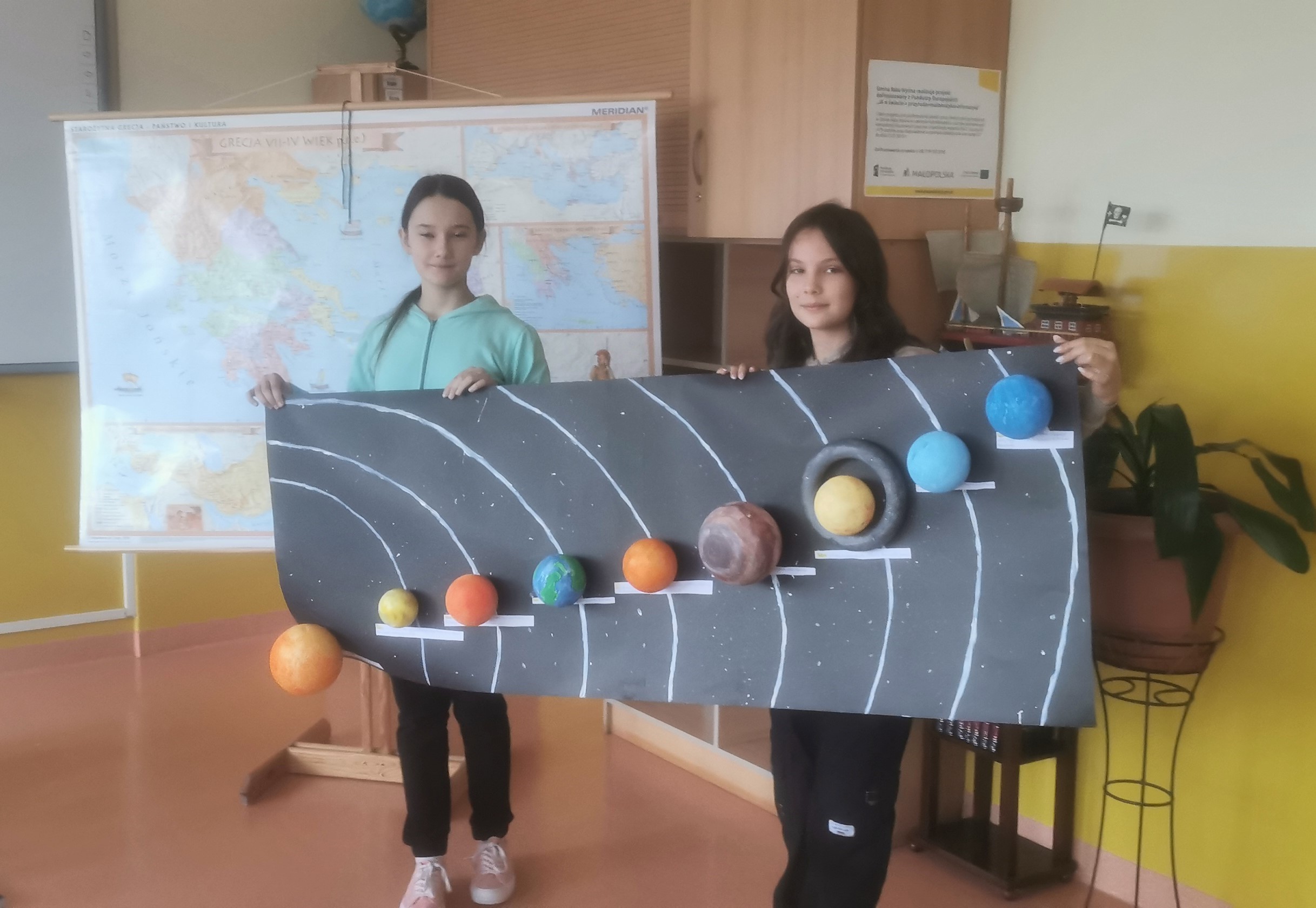 Na zdjęciu dwie uczennice trzymają model Układu Słonecznego